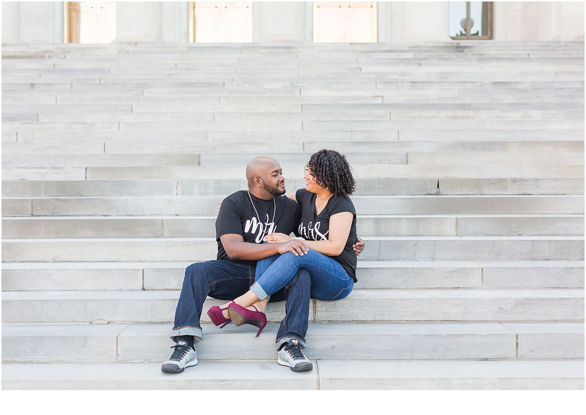 man and woman sitting on steps smiling engagement session