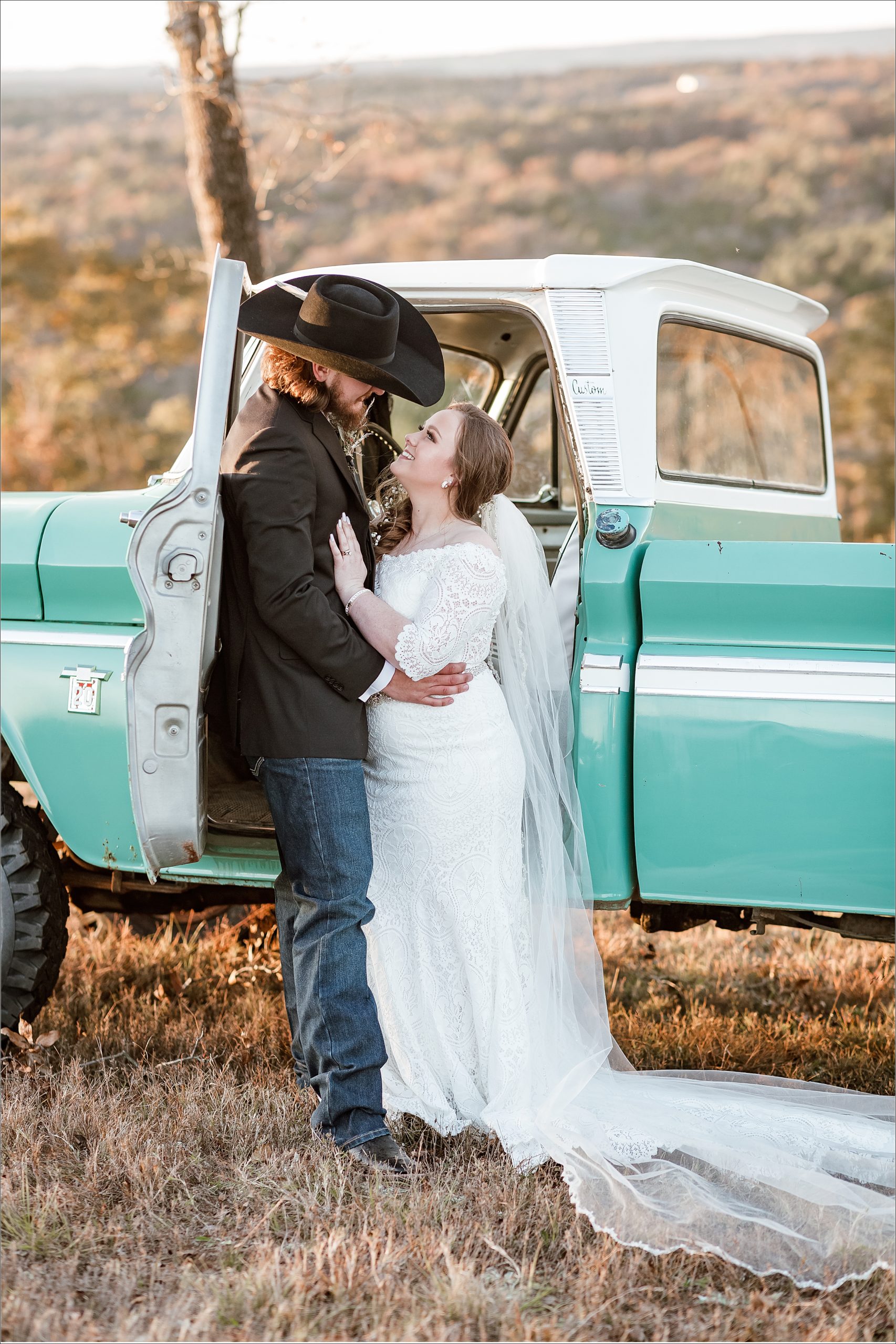 bride and groom smiling at each other outside in the door of a vintage chevy truck at Hillbrook Farms