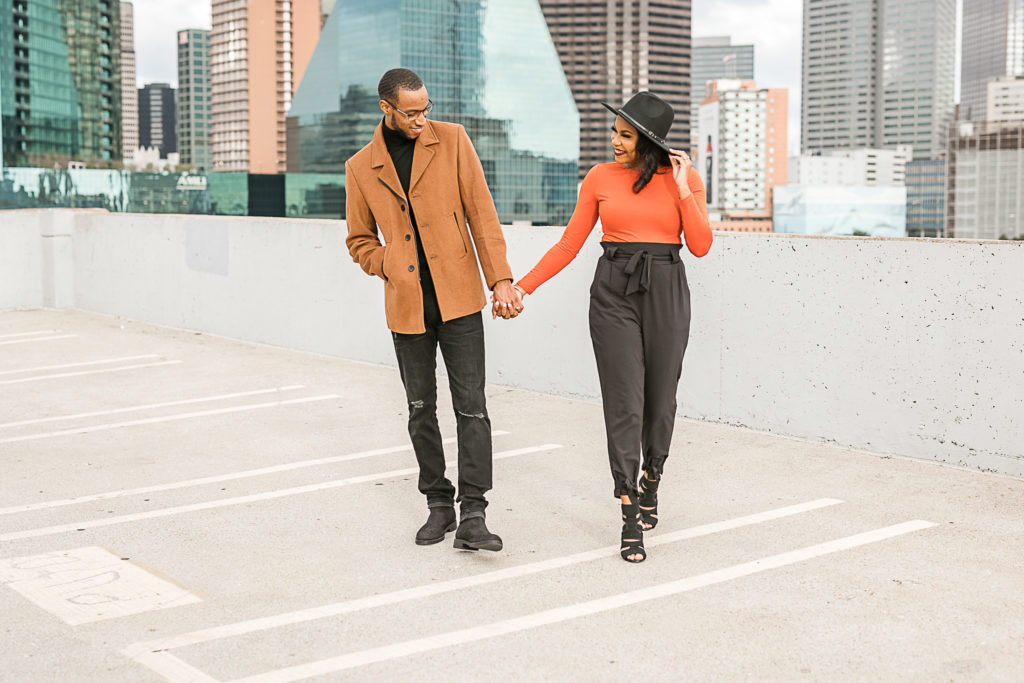 man and woman walking smiling at each other during their downtown dallas engagement session