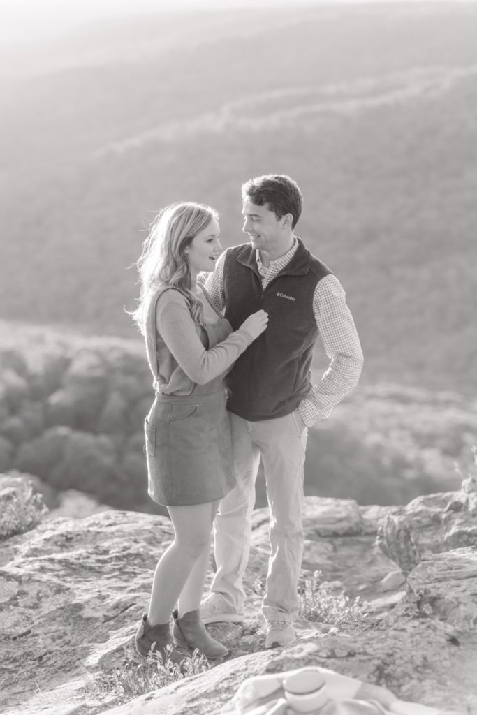 woman and man sharing a kiss at white rock mountain arkansas during their surprise proposal